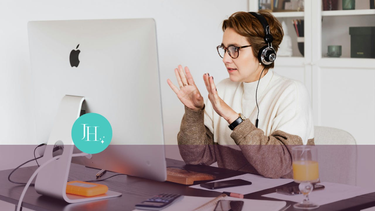 a woman wearing headphones and talking to a computer