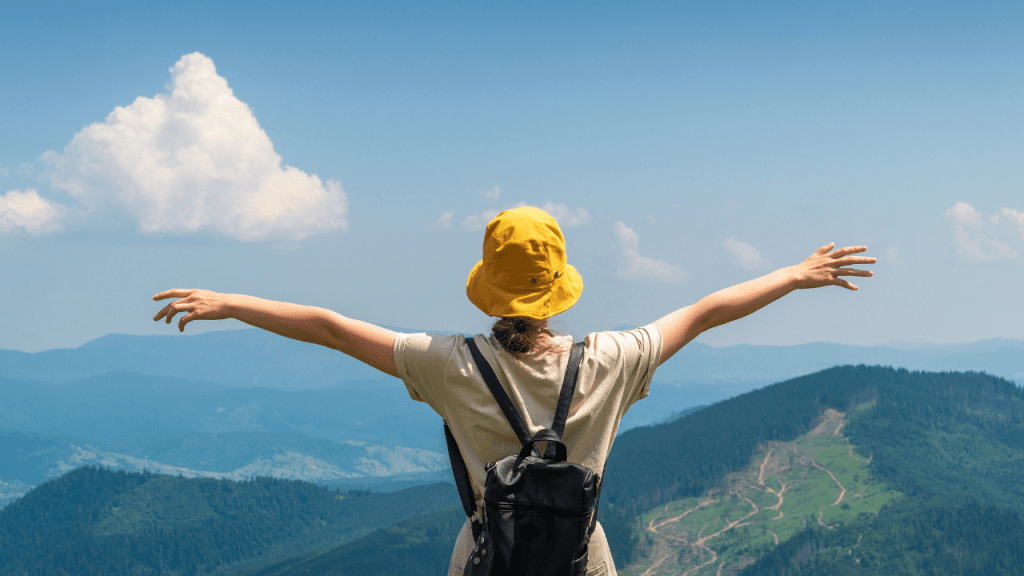 Girl traveler with backpack stands with her arms outstretched out - controlling what you can control