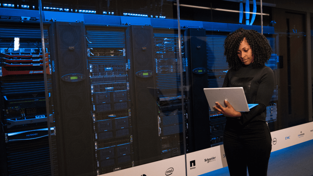 Software Engineer Standing Beside Server Racks - High-Achieving Women